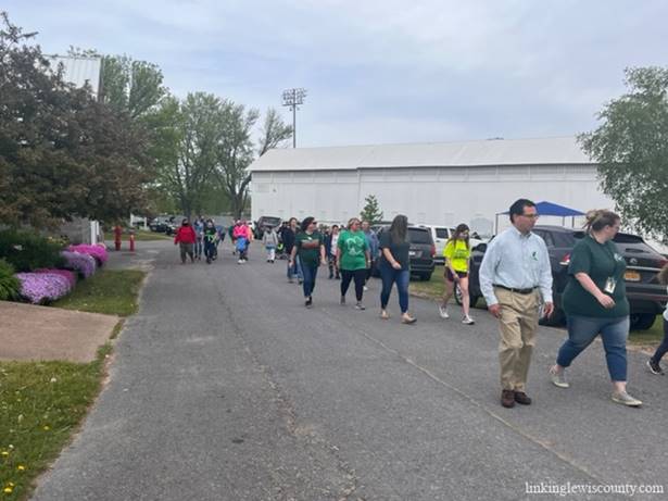 A group of people walking on a road

Description automatically generated with medium confidence
