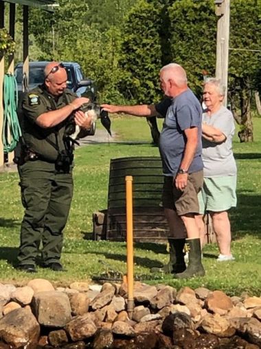 ECO holding large bird while two other people look on