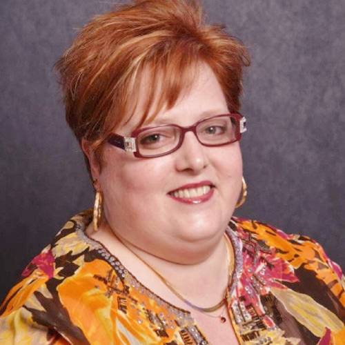 A person with red hair wearing glasses

Description automatically generated with low confidence