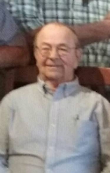A person wearing glasses and smiling

Description automatically generated