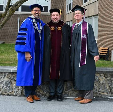A group of men in graduation gowns

Description automatically generated