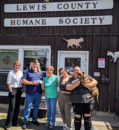 A group of people standing in front of a building

Description automatically generated