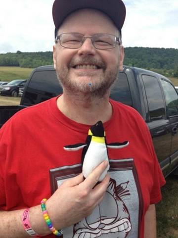 A person holding a stuffed penguin

Description automatically generated