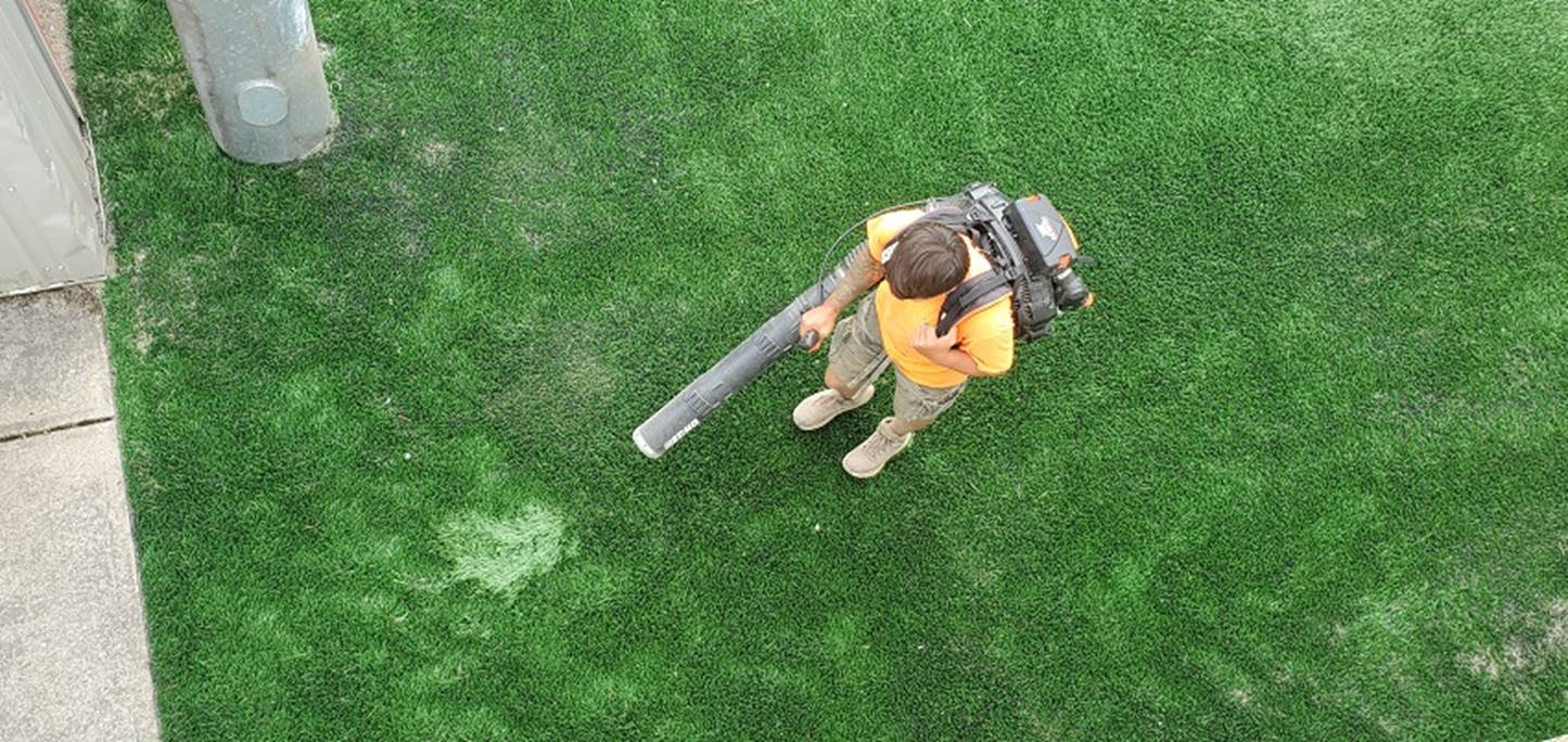 A person holding a large pipe in grass

Description automatically generated