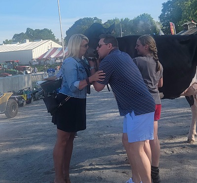 A person and person kissing a cow

Description automatically generated