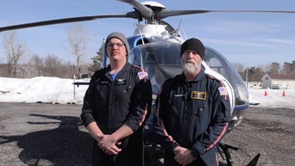 A couple of men standing in front of a helicopter
AI-generated content may be incorrect.