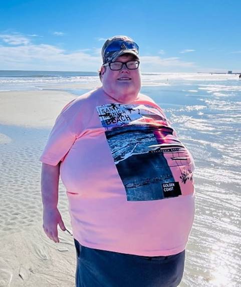 A person wearing a pink shirt and hat standing on a beach

AI-generated content may be incorrect.