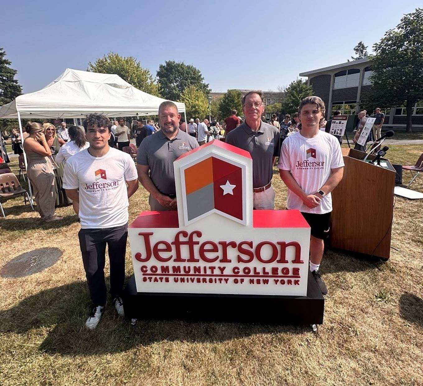 A group of people standing in front of a sign

AI-generated content may be incorrect.