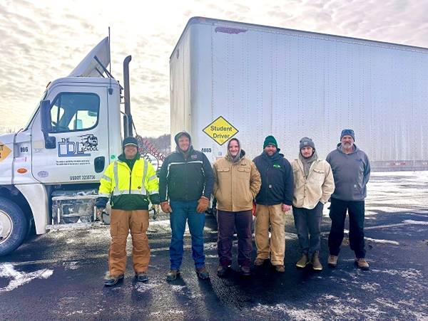 A group of men standing in front of a truck

AI-generated content may be incorrect.
