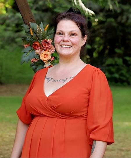 A person in an orange dress with flowers on her shoulder

AI-generated content may be incorrect.