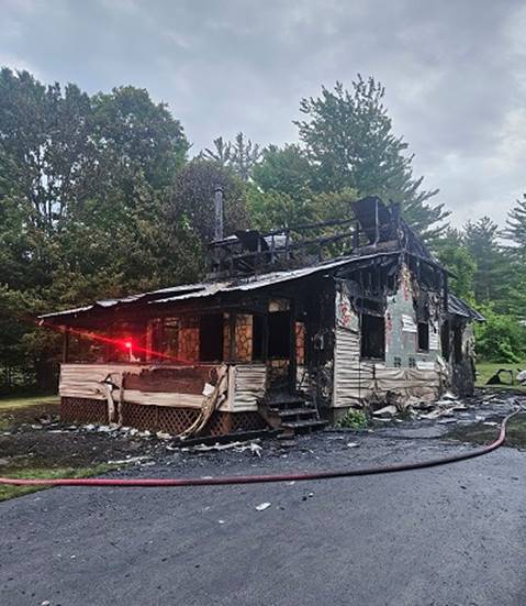 A burned down house with a fire hose

AI-generated content may be incorrect.