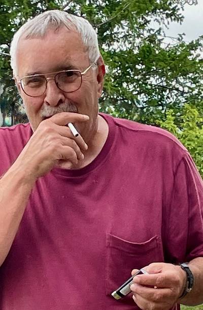 A person in a red shirt smoking a cigarette

AI-generated content may be incorrect.
