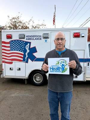 A person holding a sign in front of an ambulance

AI-generated content may be incorrect.