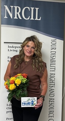 A person holding flowers in front of a sign

AI-generated content may be incorrect.