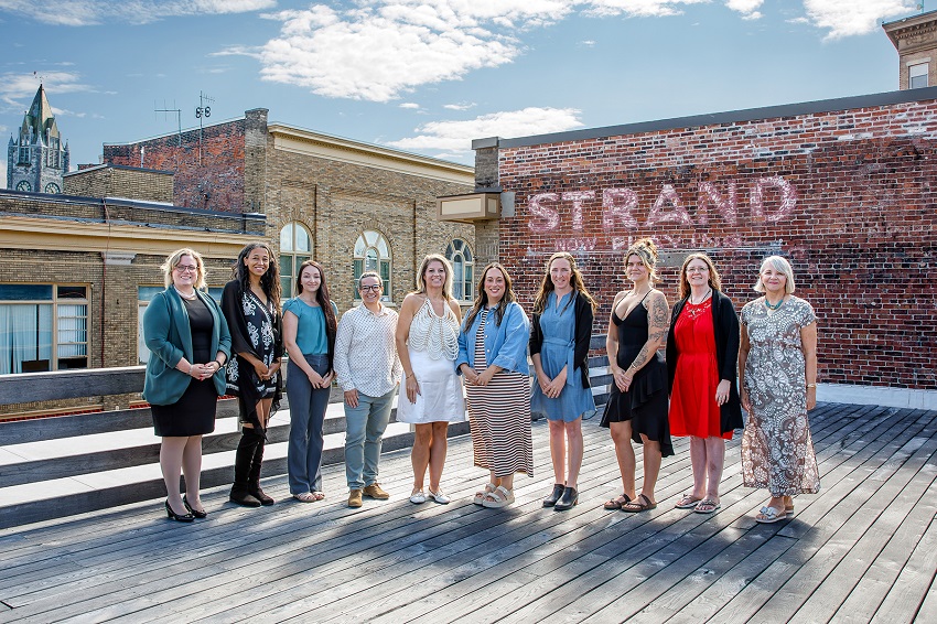 A group of women standing on a wooden deck

AI-generated content may be incorrect.