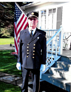 A person in uniform standing in front of a flag

AI-generated content may be incorrect.